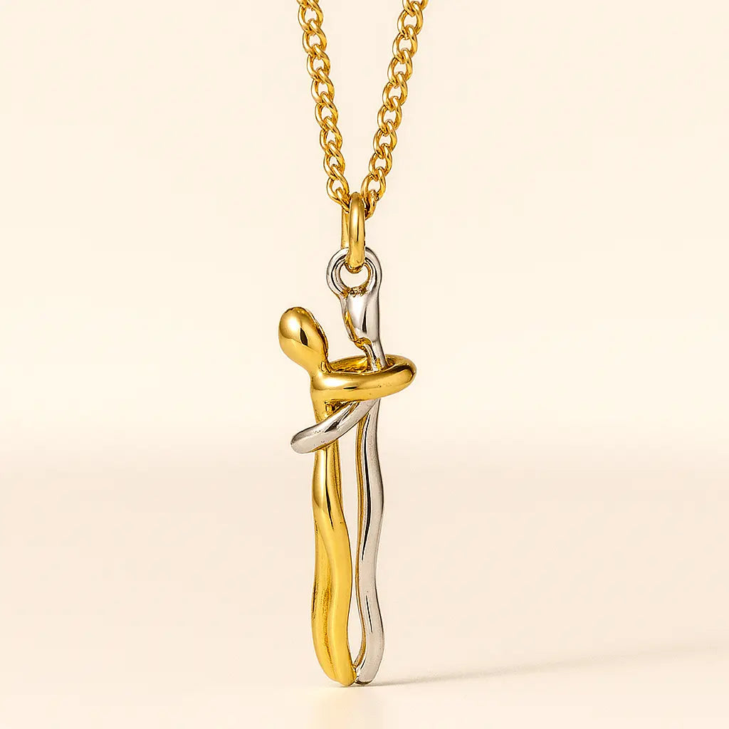 Gold and silver pendant necklace on a beige background