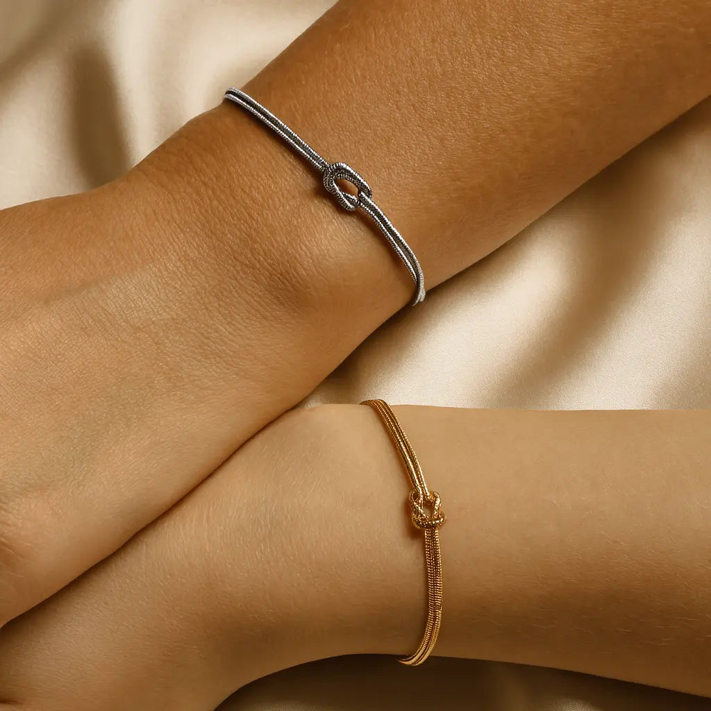 Two bracelets on a person's wrist against a beige background