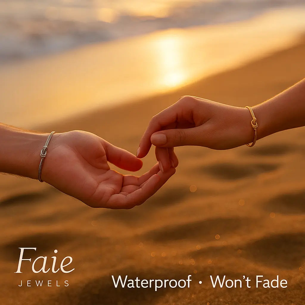 Two hands holding fingers on a beach with sunset, featuring Faie Jewels branding.
