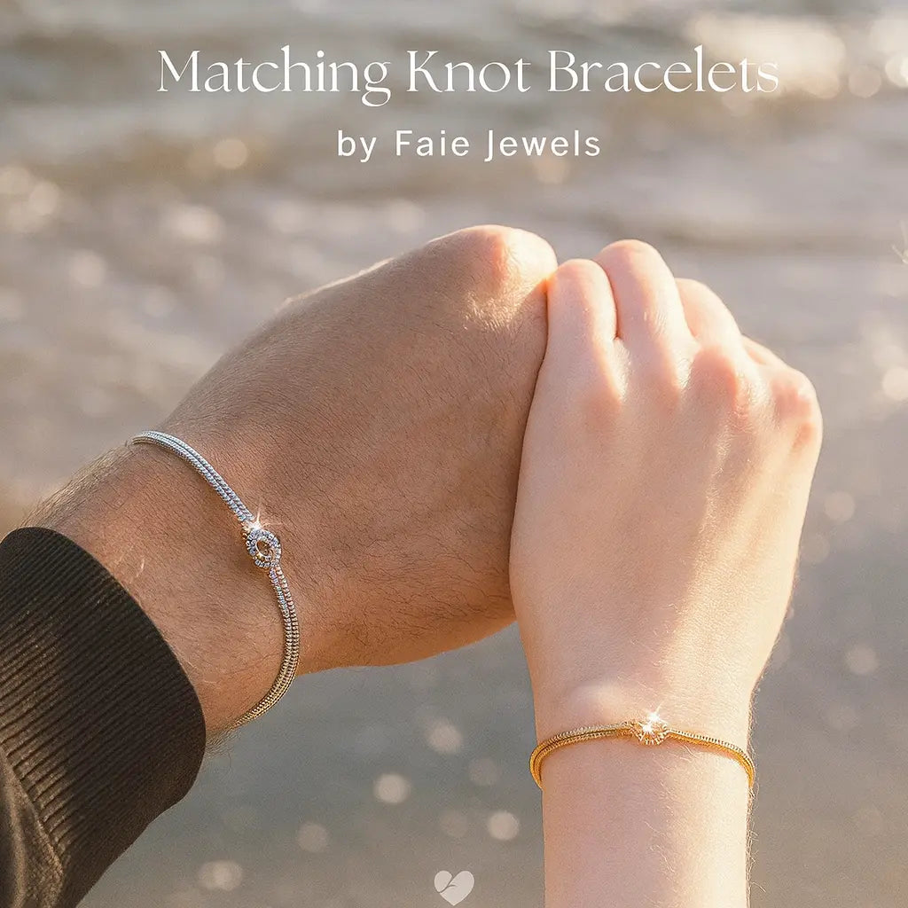 Two hands holding each other with matching knot bracelets by Faie Jewels on a blurred beach background.