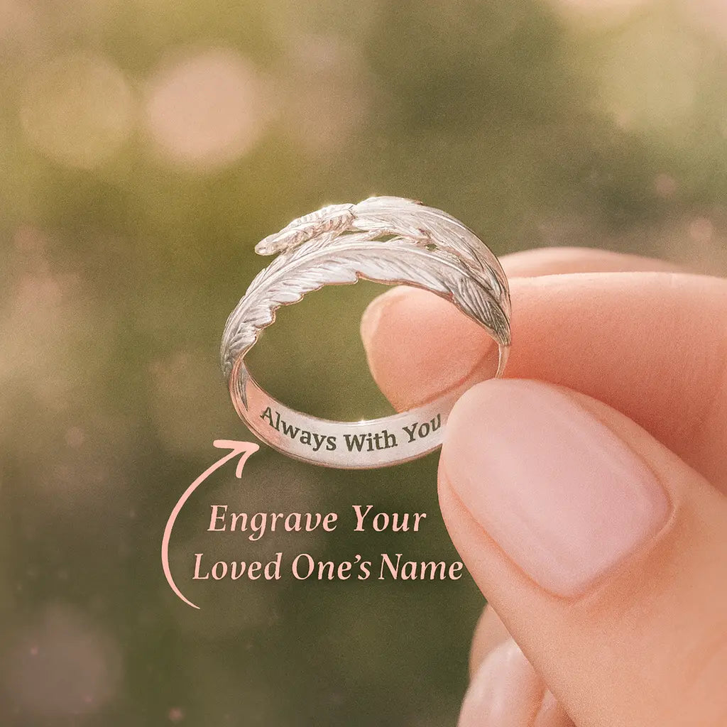 Silver ring with engraved text held by a hand against a blurred background
